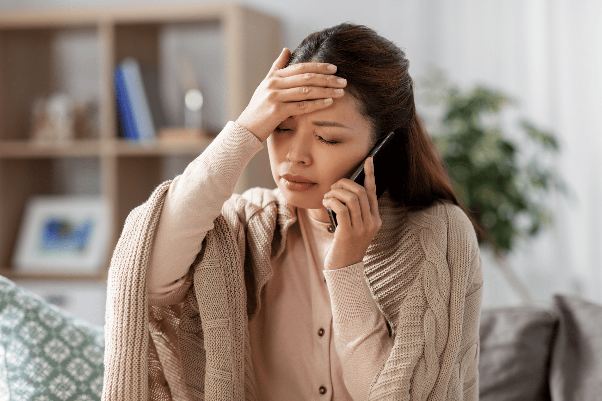 woman talking on phone with headache