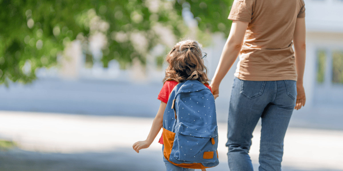 Mother walking her daughter to school
